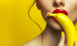 Close-up of sexy Woman Biting Banana. A close-up shot of a woman with red lipstick biting a banana on a vibrant yellow background, copy space.