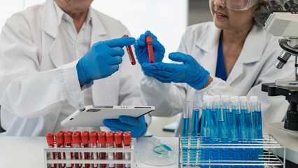 test tube microscope two senior clinical workers, two men and women in the laboratory, two scientist