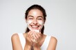 Woman with protective skin care cream and moisturizer lotion on her face happy smiling on white background
