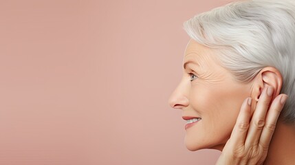 Wall Mural - Ear of Mature woman with hearing problem on pastel color background