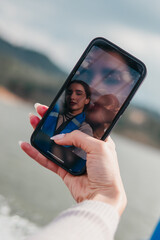 a woman is holding a cell phone up to her face, taking a selfie. concept of self-expression and conf