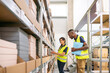 © Hernandez & Sorokina/Stocksy - Logistic Workers Working Together At Warehouse Storage