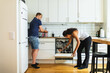 © Diego Martin/Stocksy - Friends cleaning kitchen