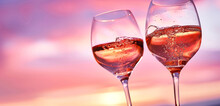 A Pair Of Wine Glasses Clinking, Filled With Sparkling Rose