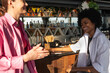 © Olga Moreira/Stocksy - Two women having fun at the bar counter