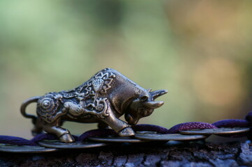 Wall Mural - A metal bull figurine with Chinese coins. Horoscope and astrology. Feng Shui and esotericism.