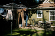 © Serena Burroughs/Stocksy - laundry hanging on drying rack in front of home