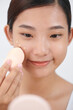 © Marc Tran/Stocksy - Beautiful model holds cotton sponge close to face