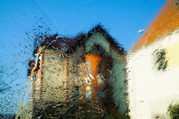 Wall Mural - Abstraktes Motiv mit Wassertropfenmuster vor hohen Altbauhäusern und hellblauem Himmel bei Frost, Sonne und Kälte am Morgen im Winter