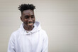 © Lupe Rodríguez/Stocksy - black man with sweatshirt in front of a white colored background