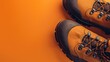 Robust hiking boots on vibrant orange background with dynamic lacing