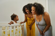 © Edward Córdoba / Andréas Sichel/Stocksy - Baby with mum and granny, all smiling by crib.