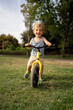 © Santi Nuñez/Stocksy - Little boy on bike in park