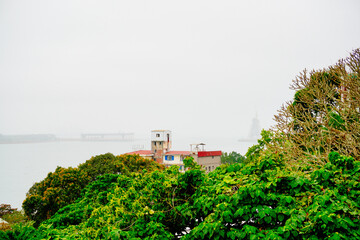 Wall Mural - Bali, New Taipei, Taiwan, Republic of China, 01 22 2024: Cruise ferry boat and port on Clean Tamsui river in a raining day in winter