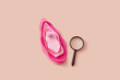 © Yaroslav Danylchenko/Stocksy - Magnifying glass lying near female vulva made of decorative materials