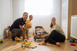 © Manu Padilla/Stocksy - Happy family sitting in room with children in daylight