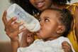 © Edward Córdoba / Andréas Sichel/Stocksy - Close-up of a young girl drinking milk from a baby bottle