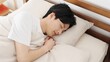 © mapo - 寝返りを打つアジア人男性