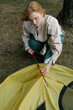 © DZ FILM/Stocksy - A woman sets up a tent