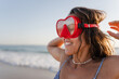 © Raul Navarro/Stocksy - portrait of a woman with red diving goggles at the beach