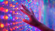 © Justlight - A persons hand is seen reaching out to touch a wall covered in colorful responsive lights in an interactive sound installation. The lights change color and emit soft musical