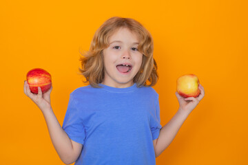 Wall Mural - Healthy fruits for kids. Kid with apple in studio. Studio portrait of cute child hold apple isolated on yellow background.