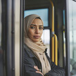 © mindstorm - Portrait of confident professional female bus driver at the station Muslim American.