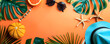 Top view flat lay of a summer background featuring starfish, oranges, beach hat, glasses, and palm leaves. An orange summer composition with space for copy or text.