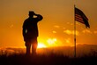 Silhouette of a military person saluting the American flag at sunset.