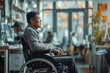 an asian man on a wheelchair shows in the office working with others