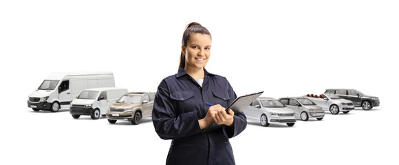 Wall Mural - Female technician in a uniform holding a clipboard in front of vehicles