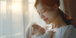 Asian beautiful woman holding newborn child. Banner with copyspace. Shallow depth of field.