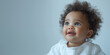 Banner with little cute afroamerican baby girl looking up over  blue and grey background with copyspace.