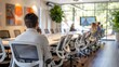 © Татьяна Креминская - Man in grey at a modern, bright office meeting with ergonomic chairs, greenery outside, and a blurred presentation.