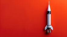 White Rocket Model Centered On A Vibrant Red Backdrop