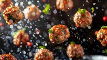 a group of meatballs flying through the air with sprinkles of seasoning on top of them.