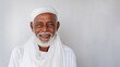 Closeup photo portrait of a smiling elderly South Asian man wearing a white turban and robe on a white background