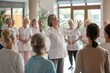 A physiotherapist leads a group of seniors in healthy stretching exercises in a fitness class at the nursing home