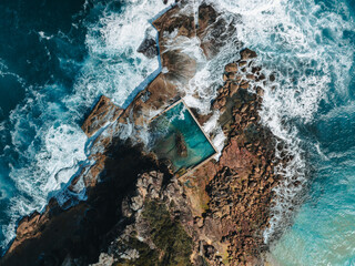 Wall Mural - aerial view early morning light with ocean waves flowing over rocks around north curl curl ocean roc