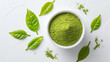 Matcha green tea powder in bowl with green leaves isolated on the white background