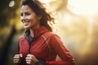 A woman in a red jacket running outdoors. Suitable for fitness or active lifestyle concepts