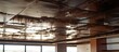 A room in an office building with a ceiling covered in significant rust, likely due to water damage. The brown stains indicate a longstanding issue that needs attention.
