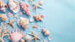 Collection of beautiful seashells and corals scattered on a pastel blue background (top view), copy space on the right