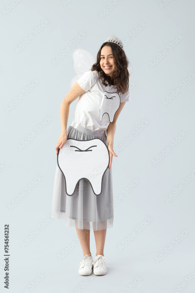 Tooth Fairy with paper figure on light background