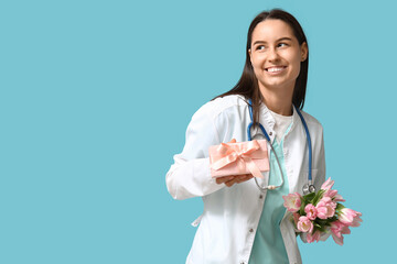 Sticker - Female doctor with pink tulips and gift box on blue background. Women's Day celebration