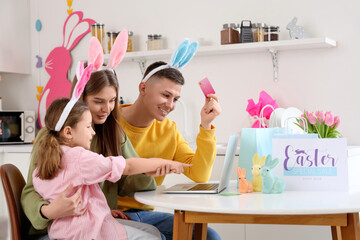 Wall Mural - Happy family with laptop shopping online in kitchen. Easter Sale