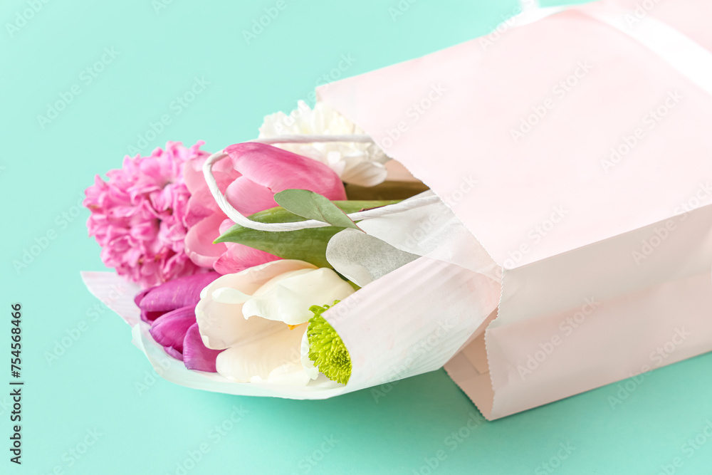 Paper shopping bag with flowers on turquoise background