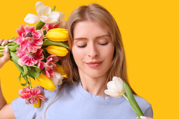 Poster - Pretty young woman with beautiful tulips on yellow background