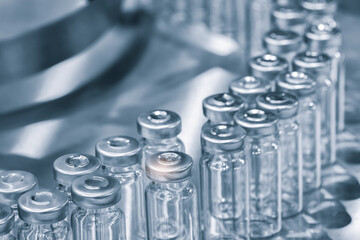 Poster - Pharmaceutical industry. Production line machine conveyor with glass bottles ampoules at factory. Pharmaceutical industry concept background.