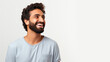 Joyful man with a beard and curly hair, laughing and looking away against a white background.